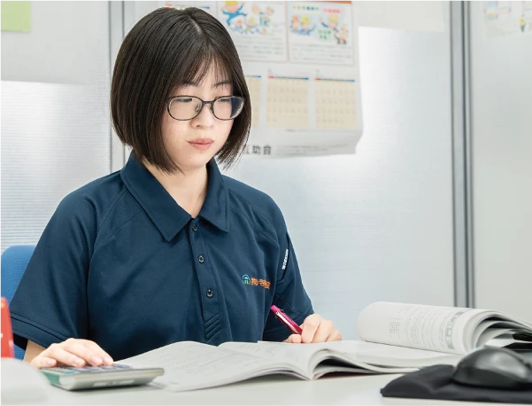 デスクで資料を確認するIさん